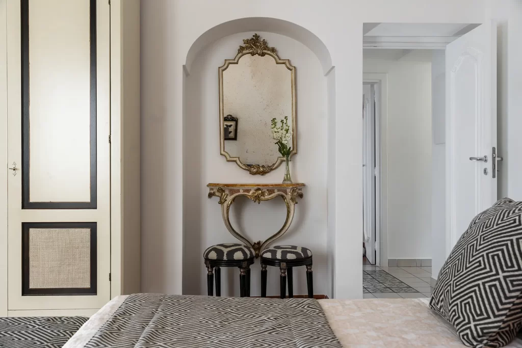 Camera da letto elegante con specchio antico e dettagli raffinati.