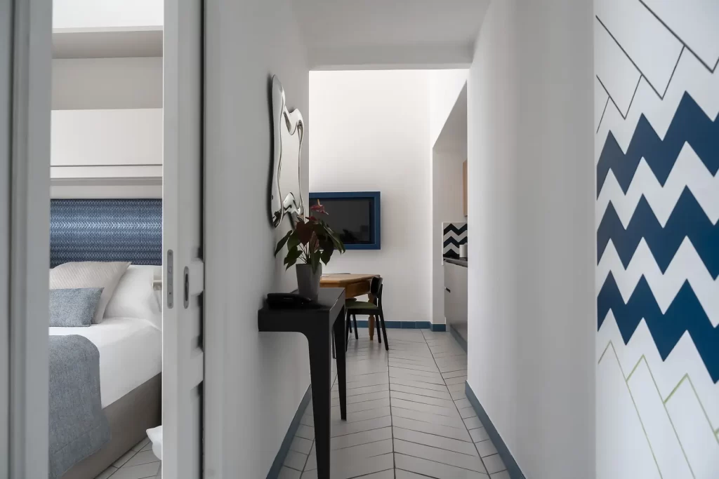 Corridoio di un appartamento moderno con arredamento minimalista e dettagli blu.