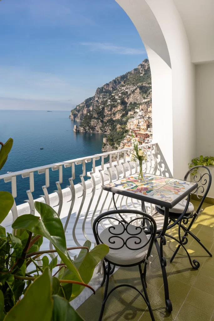 Balcone con tavolo e sedie affacciato su un panorama costiero mozzafiato.