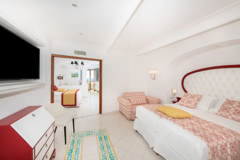 Camera da letto moderna e luminosa con letto matrimoniale, arredi eleganti e TV a schermo piatto.