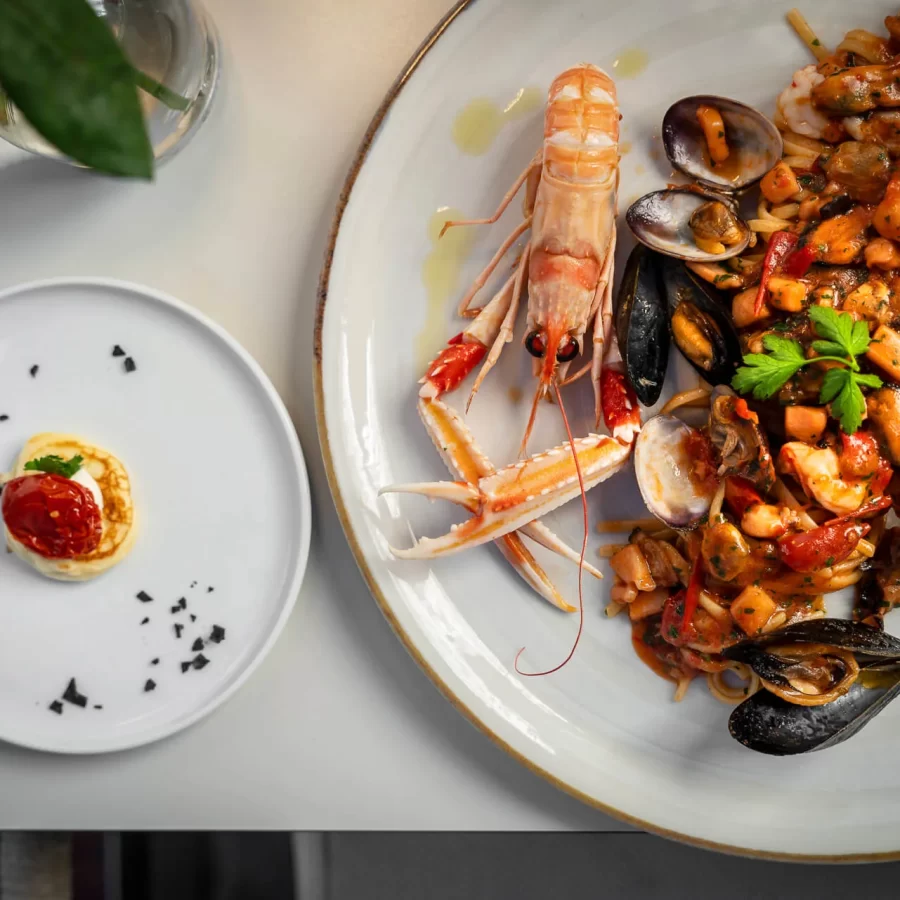 Piatto di frutti di mare con scampi e cozze su un'ampia tavola.